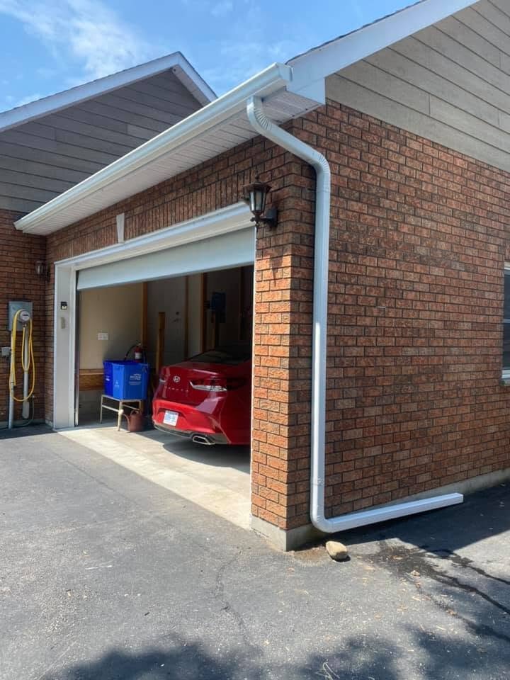 Downspout routed along the corner of a detached garage.