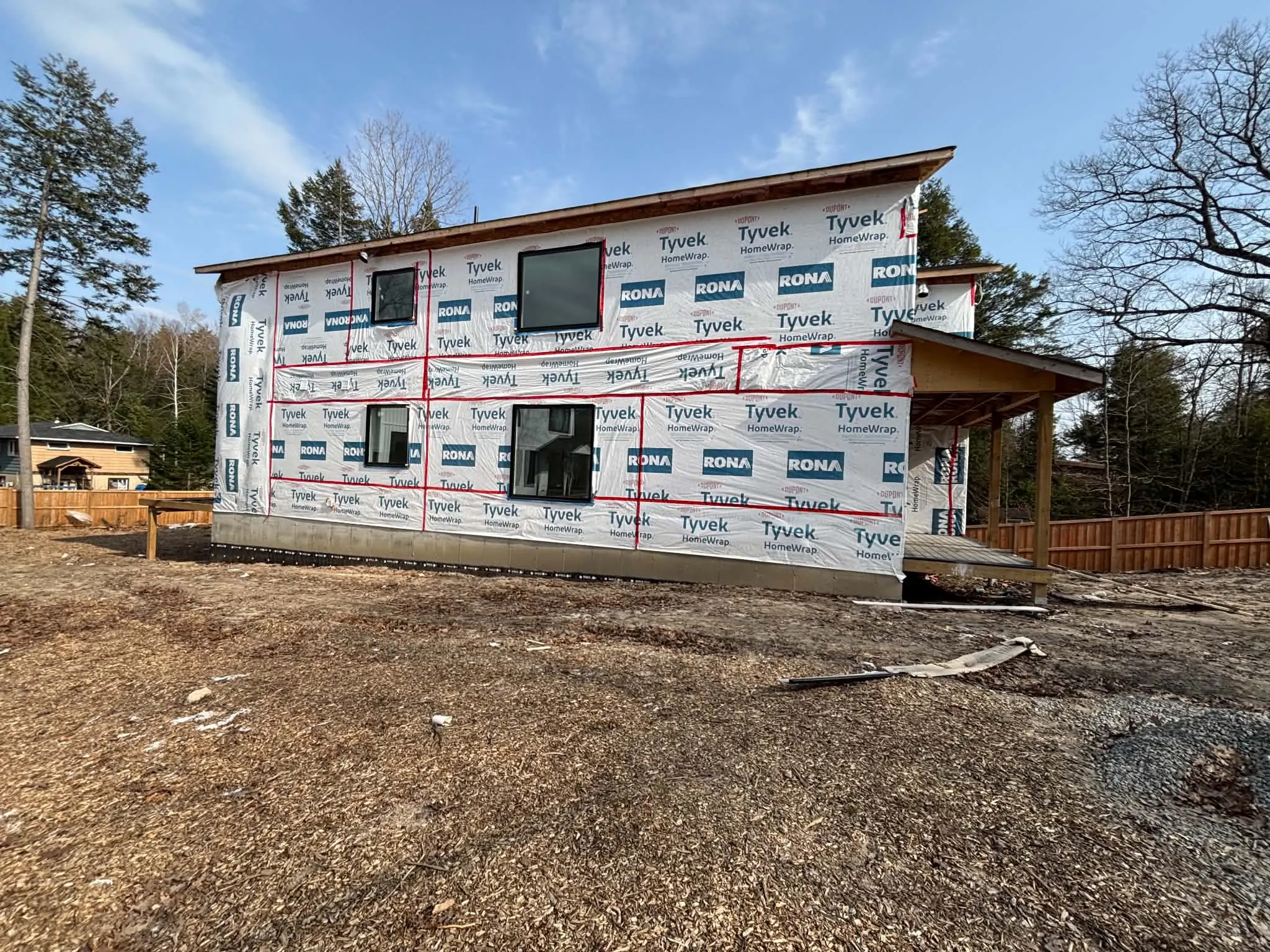 Two-storey home wrapped and prepared for siding installation.