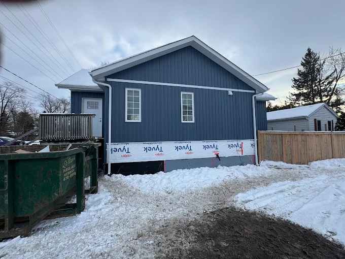 Side elevation during blue board-and-batten siding installation.