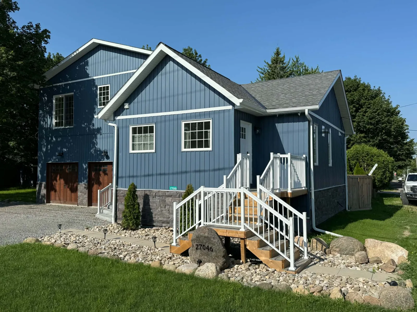 Finished blue board-and-batten siding with dark trim on the front corner of a home.