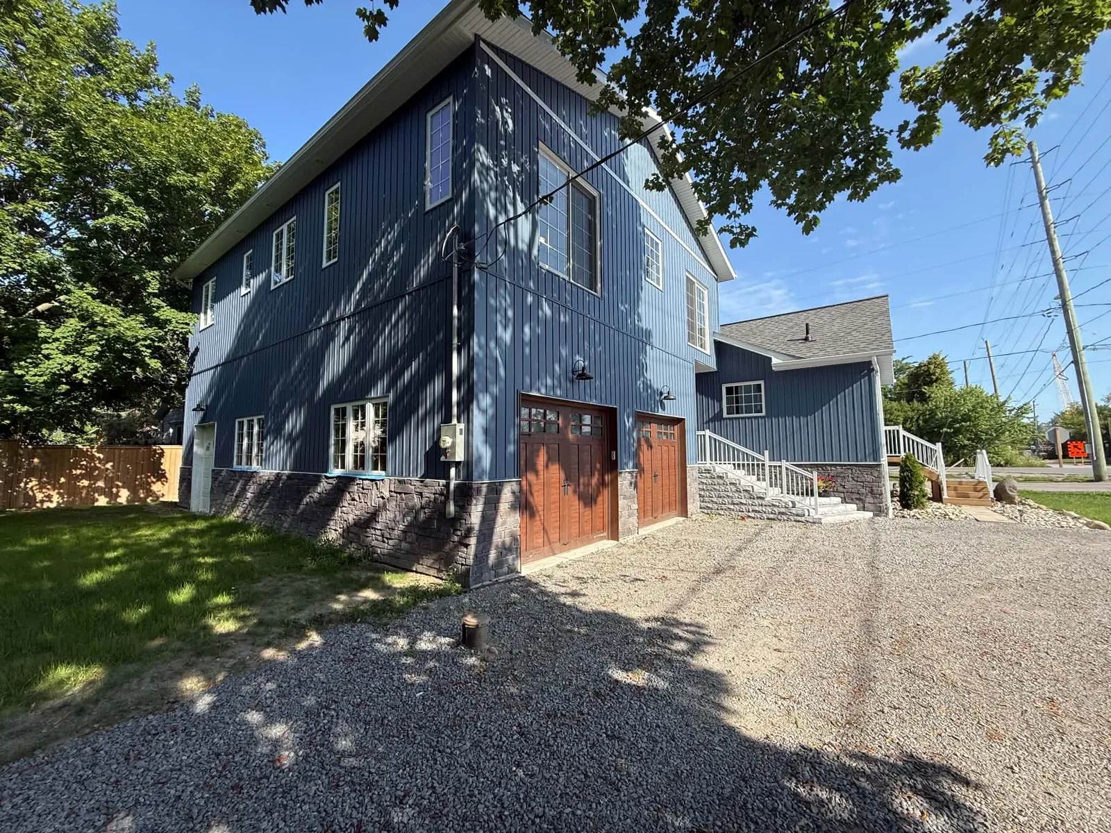 Blue board-and-batten siding completed along the garage-side elevation.