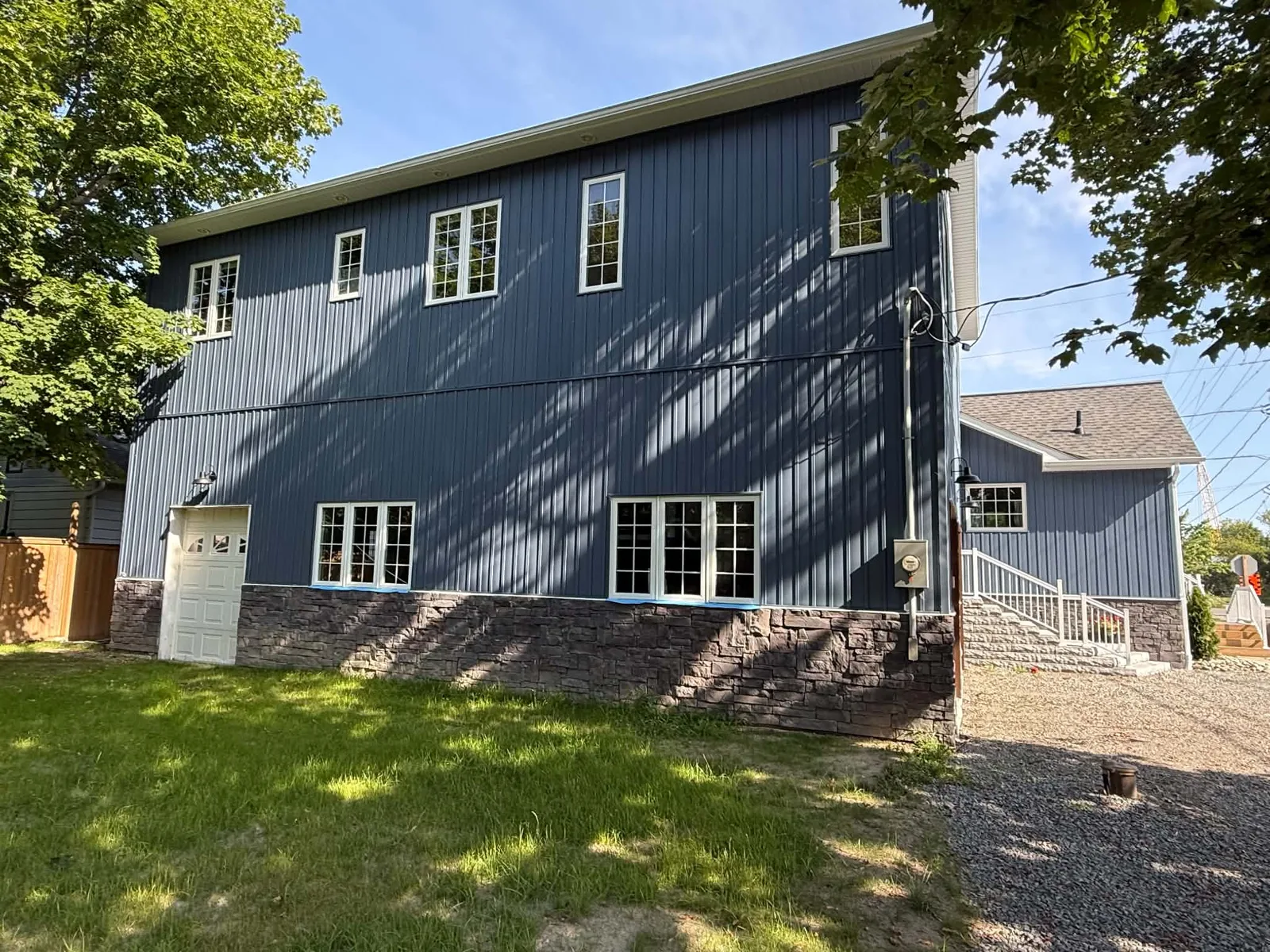 Finished blue board-and-batten siding across the rear and side elevations.