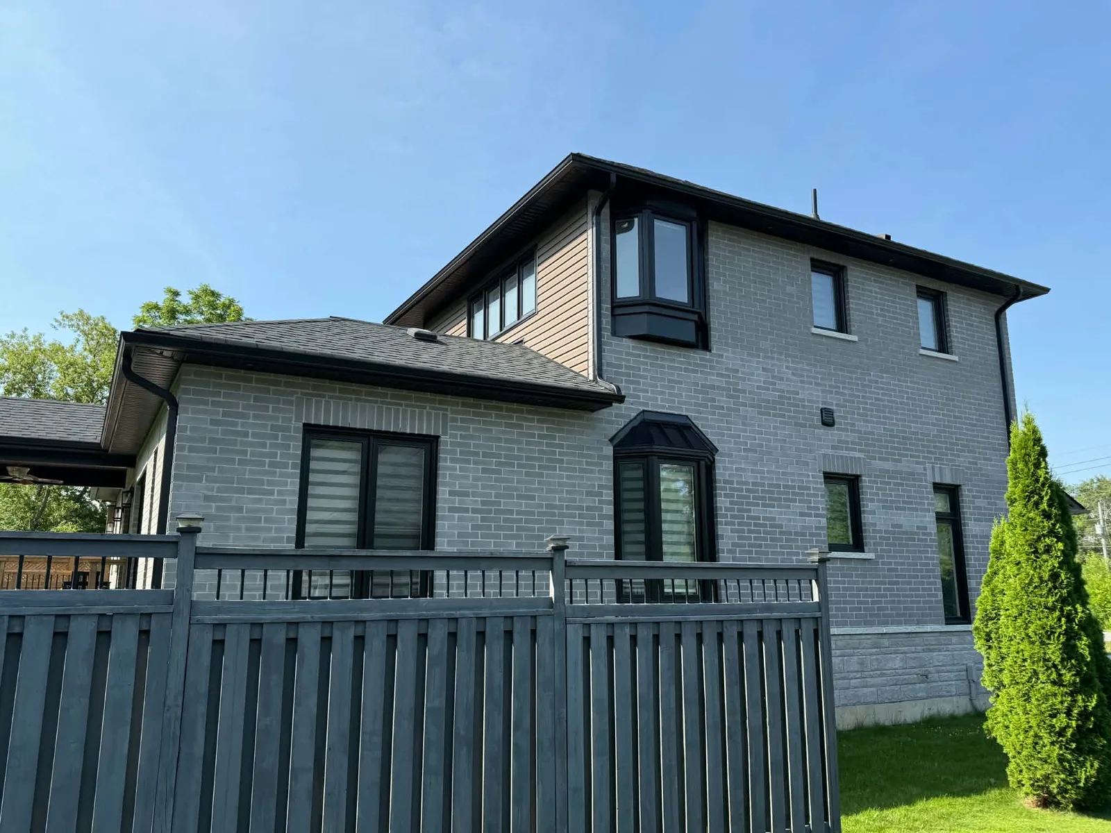 Rear elevation of a brick two-storey home with coordinated dark roofline trim.