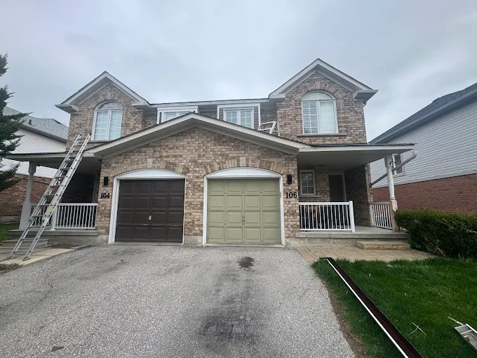 Brick two-storey home with white eavestrough, fascia, soffit, and downspouts.