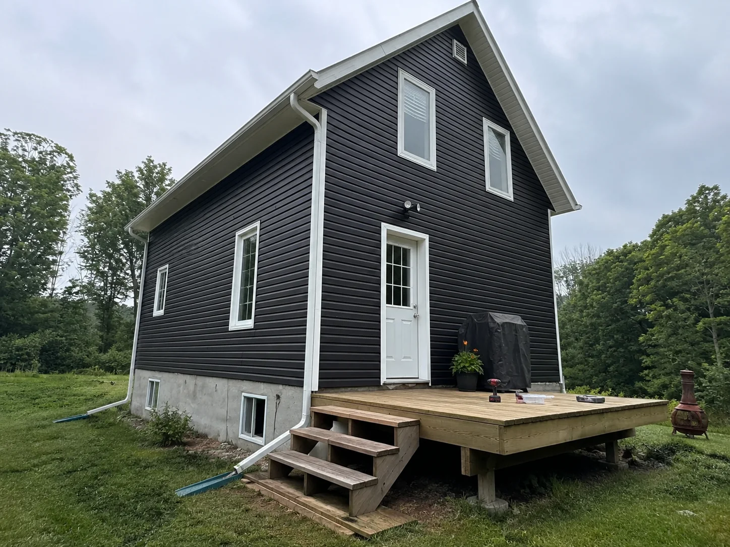 Finished dark siding and white trim around the deck elevation of the house.