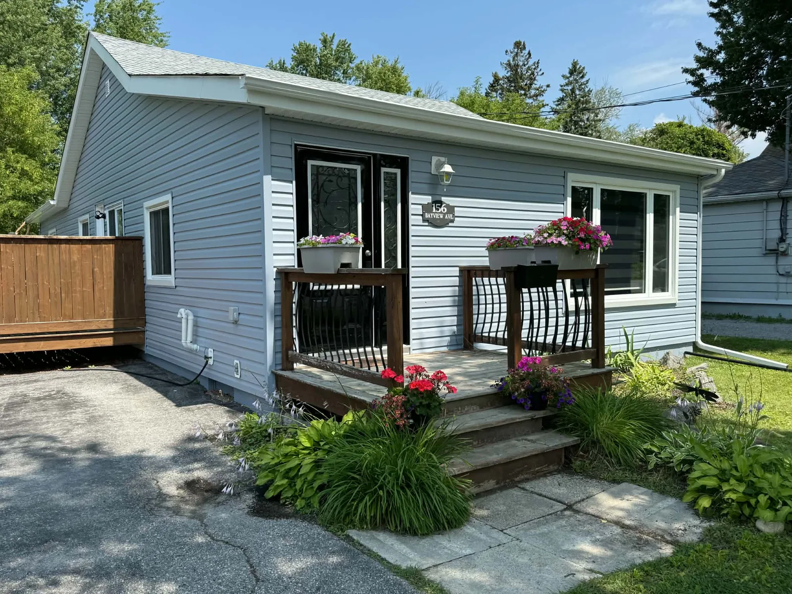 Finished bungalow entry framed by light-grey siding and clean white trim.