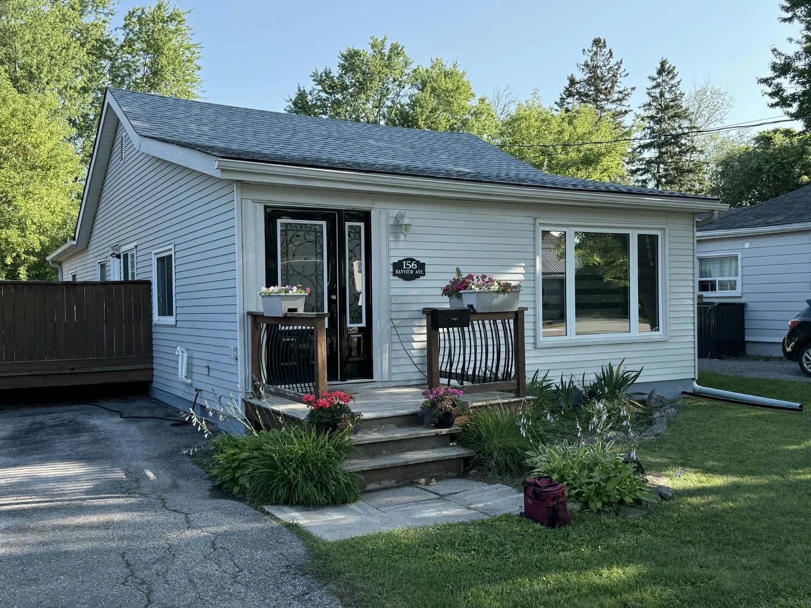Finished light-grey siding and white trim across the front elevation of a bungalow.