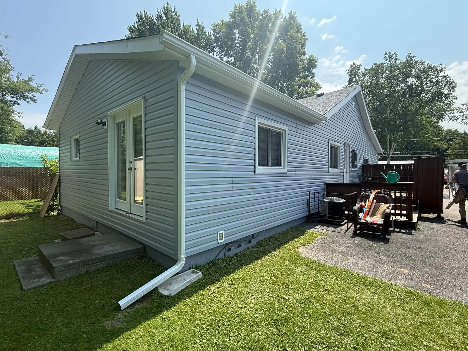 Rear elevation finished with light-grey horizontal siding and white trim.