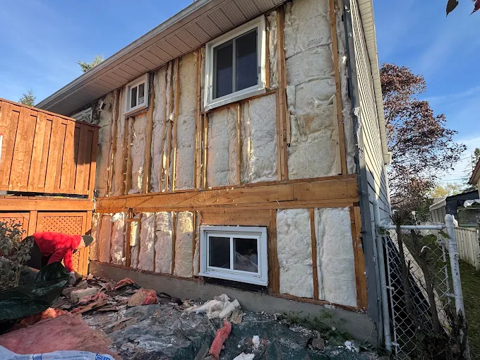 House exterior at the start of siding removal and preparation.