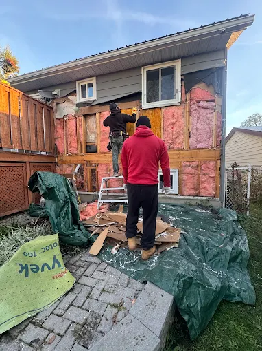 Wall wrap being installed during a siding replacement sequence.