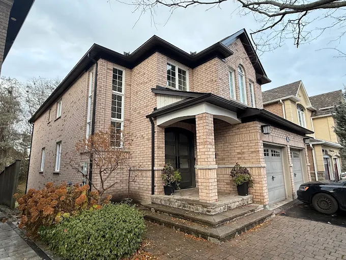Brick home with a dark eavestrough and finished roofline.