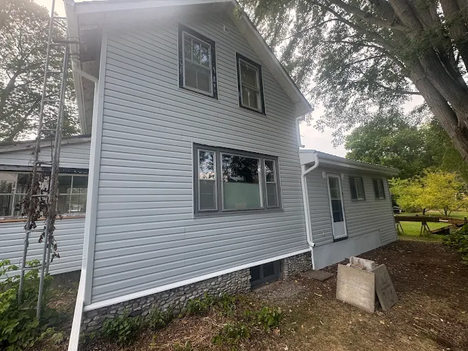 Two-storey home finished with grey horizontal siding and light trim.