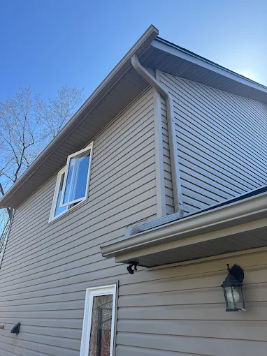 Close exterior corner showing siding, soffit, fascia, and eavestrough alignment.