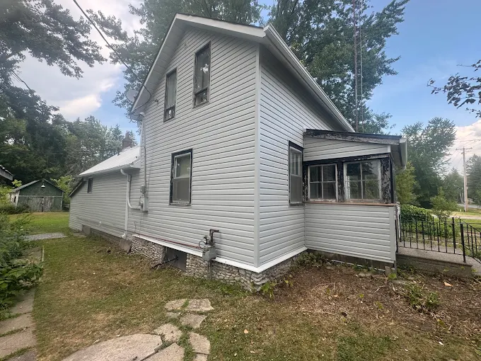 Two-storey home finished in white horizontal siding.