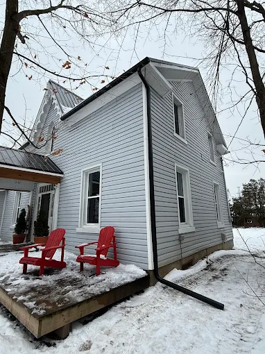 White-sided home with finished trim and roofline in winter.