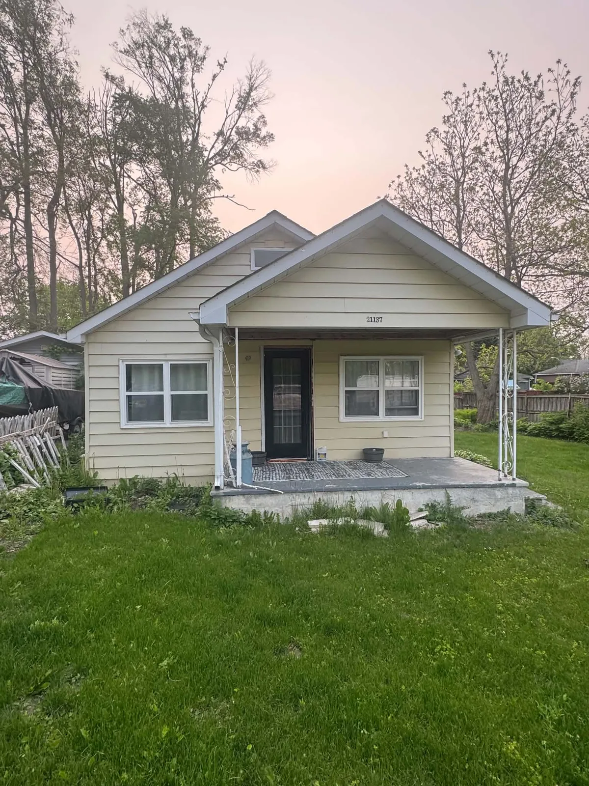 Front elevation with tan siding and porch columns before the exterior update.