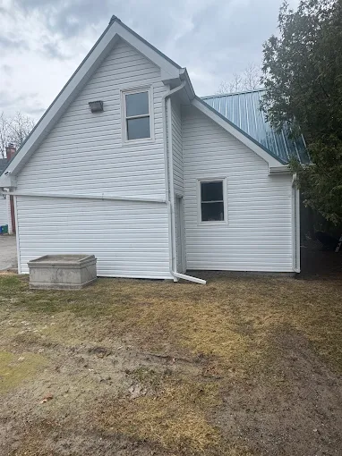 Front angle of a house finished with white horizontal siding.