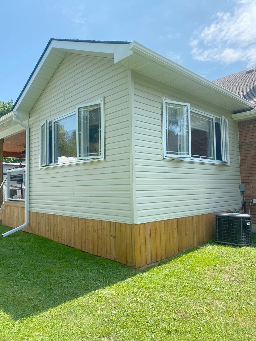 Small home addition finished with light horizontal siding and white trim.